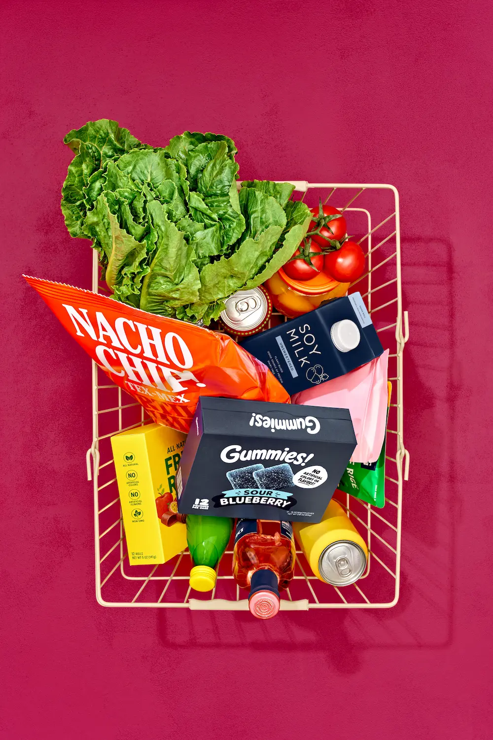 Non-UPF Verified grocery shopping basket with product mockups of nacho chips, gummies, soy milk, and fresh produce like tomatoes and lettuce.